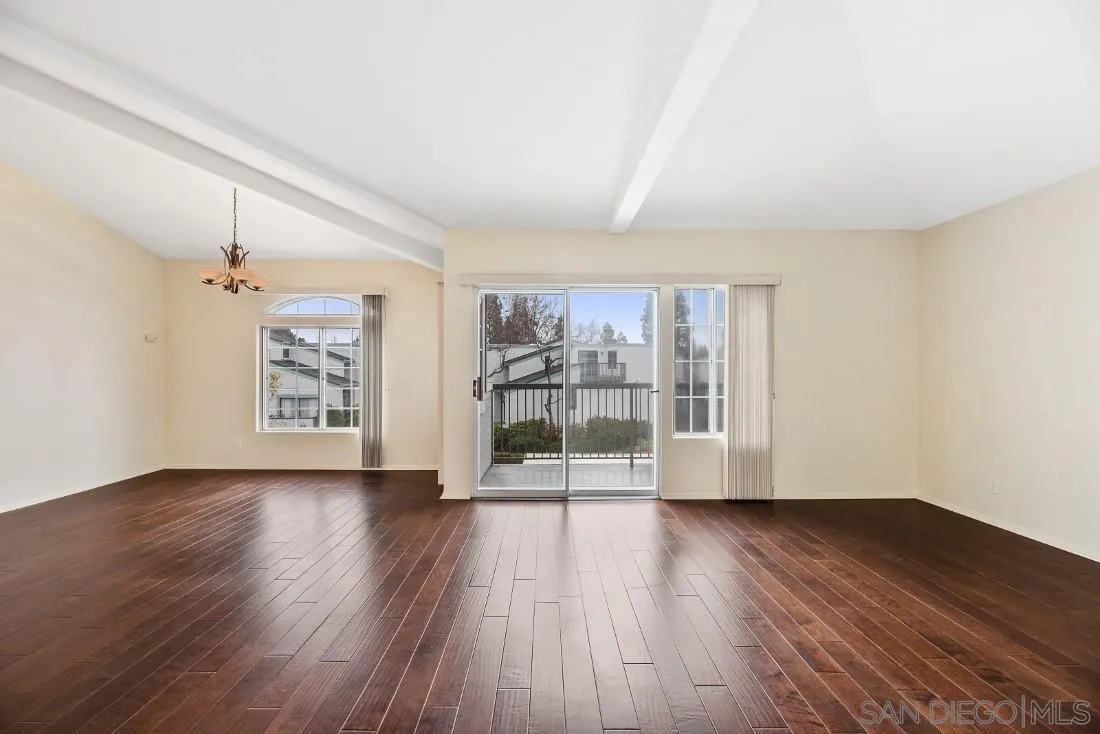 8637 Via Mallorca, Unit E La Jolla, CA 92037 - Photo 11 of 34 an empty room with wooden floor and windows