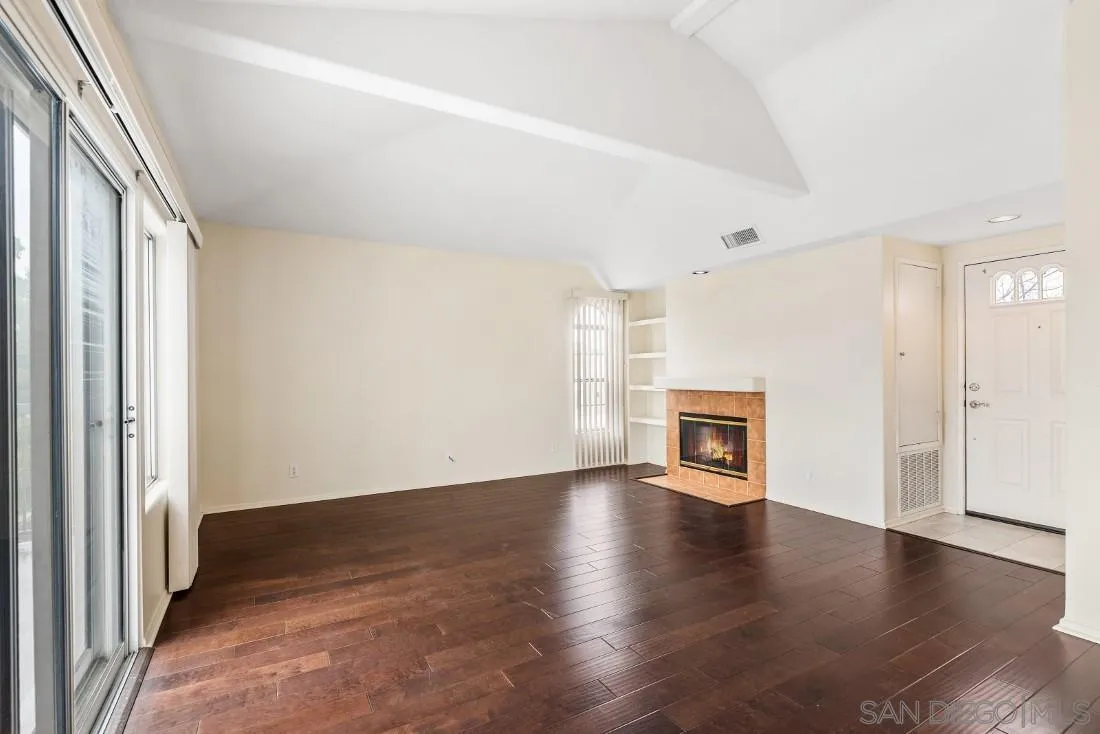 8637 Via Mallorca, Unit E La Jolla, CA 92037 - Photo 5 of 34 an empty room with wooden floor fireplace and windows