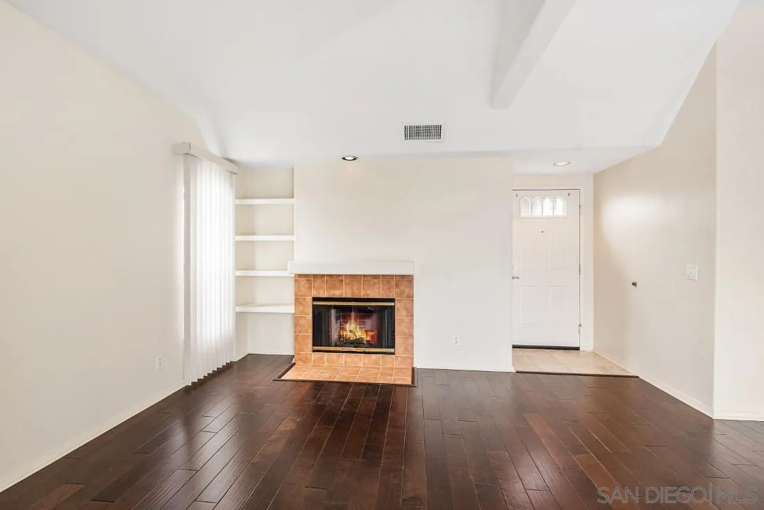 8637 Via Mallorca, Unit E La Jolla, CA 92037 - Photo 7 of 34 an empty room with wooden floor and fireplace