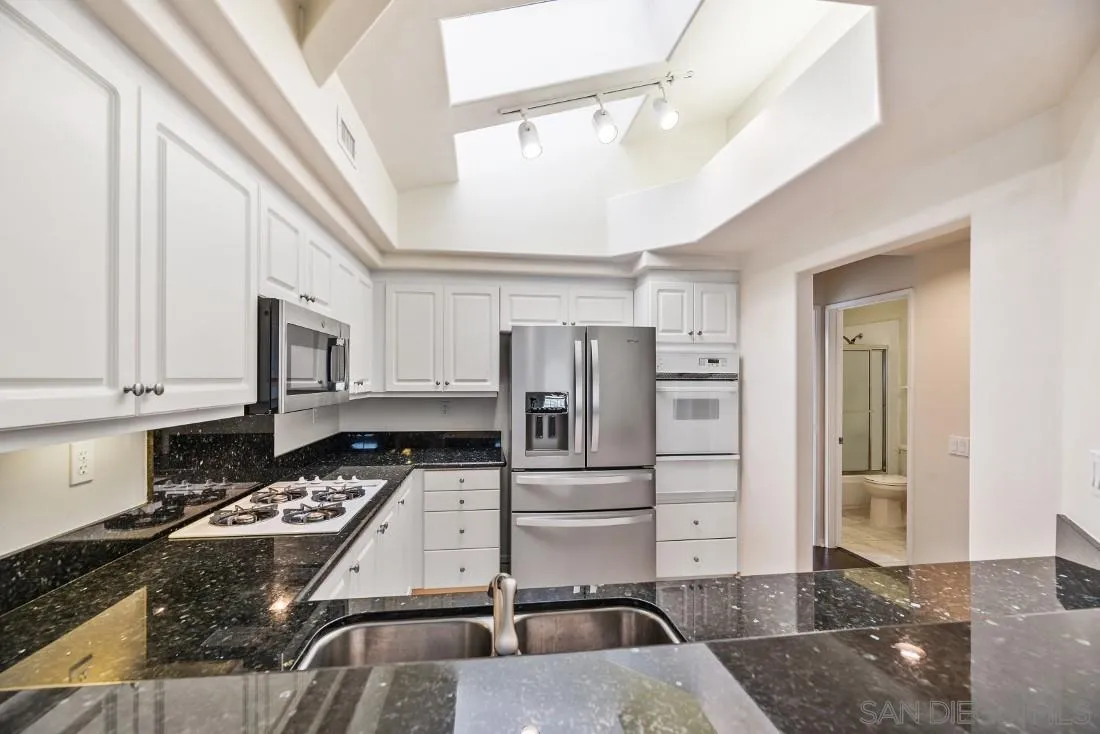 8637 Via Mallorca, Unit E La Jolla, CA 92037 - Photo 9 of 34 a kitchen with refrigerator and cabinets