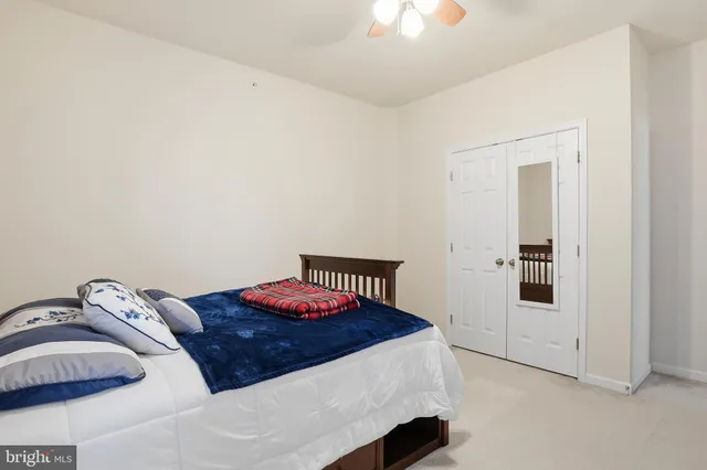 a bedroom with a bed and a chandelier fan