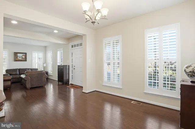 a living room with couches and a dining table with wooden floor