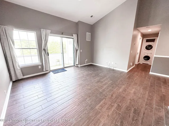 a view of a kitchen with kitchen island a sink wooden floor and a refrigerator