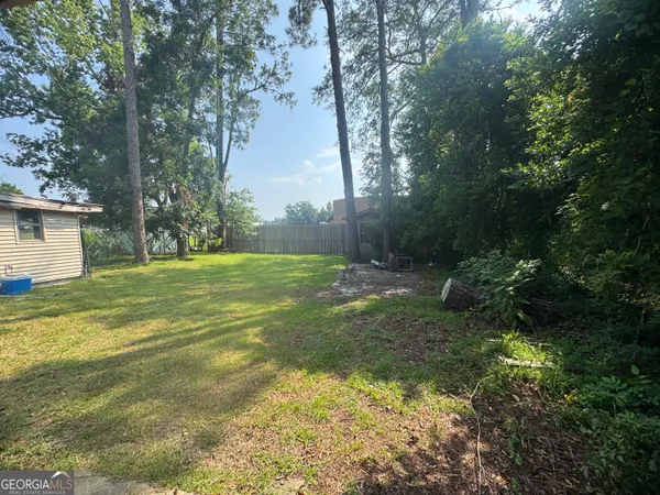 a view of a house with backyard and sitting area