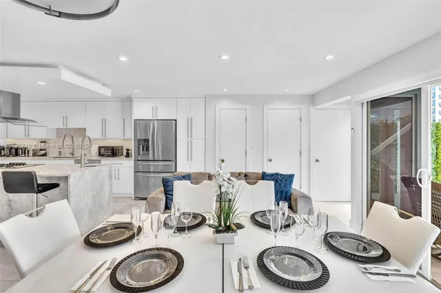 a kitchen with stainless steel appliances kitchen island granite countertop a refrigerator and a sink