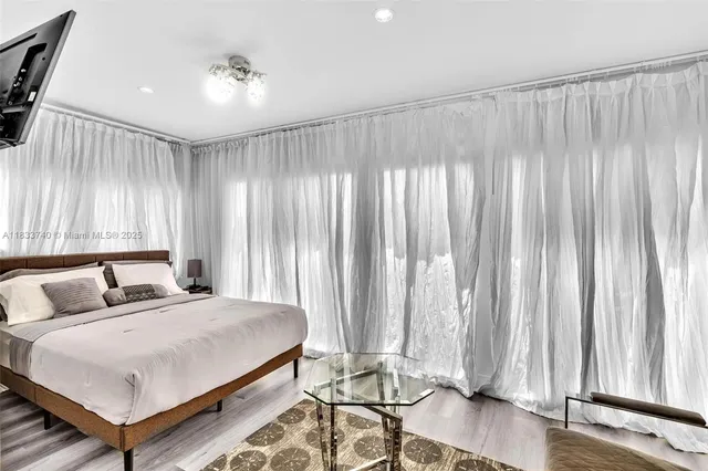 a spacious bedroom with a bed and a flat screen tv