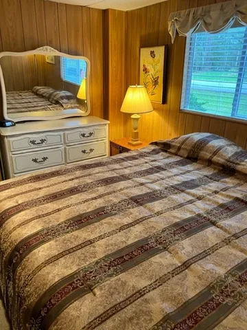 a bedroom with a bed and painting on the wall