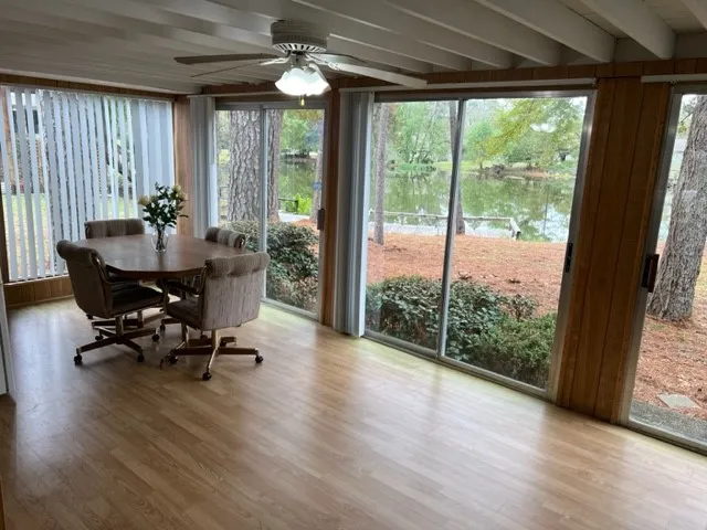 a dining room with wooden floor glass table and chairs