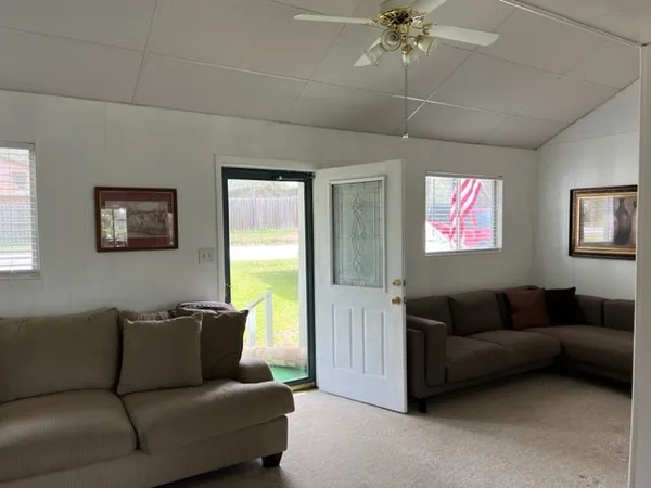 a living room with furniture and a ceiling fan
