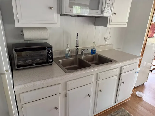 a kitchen with white cabinets and a sink