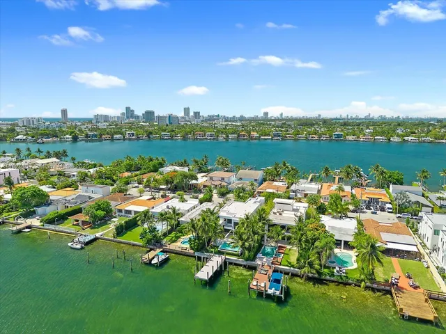 an aerial view of residential houses with outdoor space and lake view