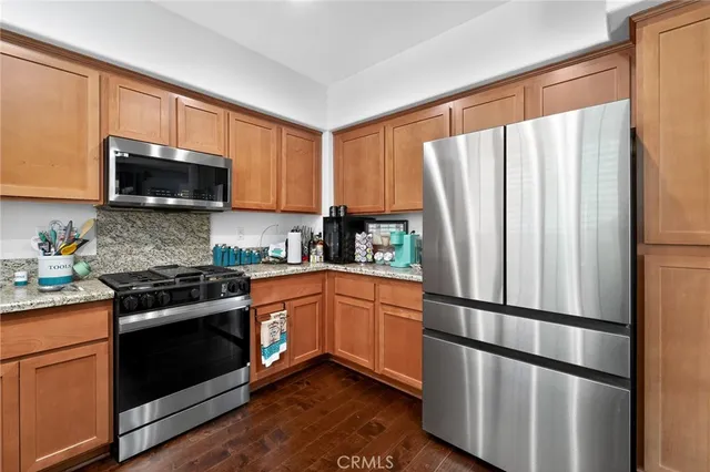 a kitchen with stainless steel appliances granite countertop a refrigerator stove a sink and a microwave