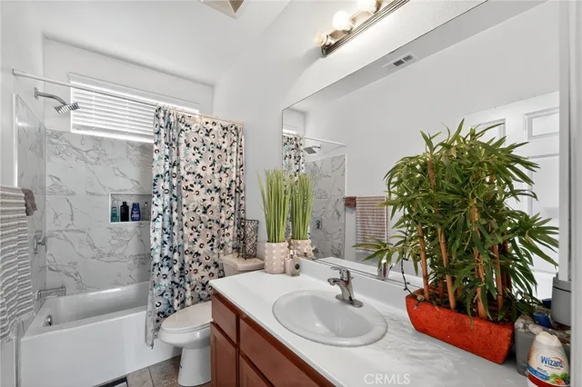 a bathroom with a granite countertop sink a toilet and shower