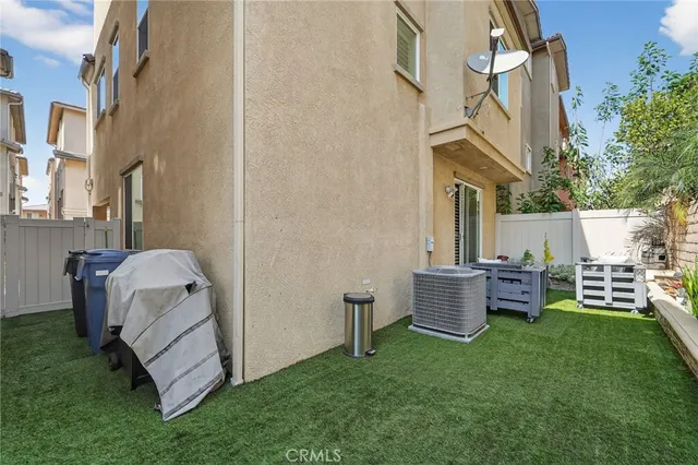 a view of a chair and table in backyard of the house