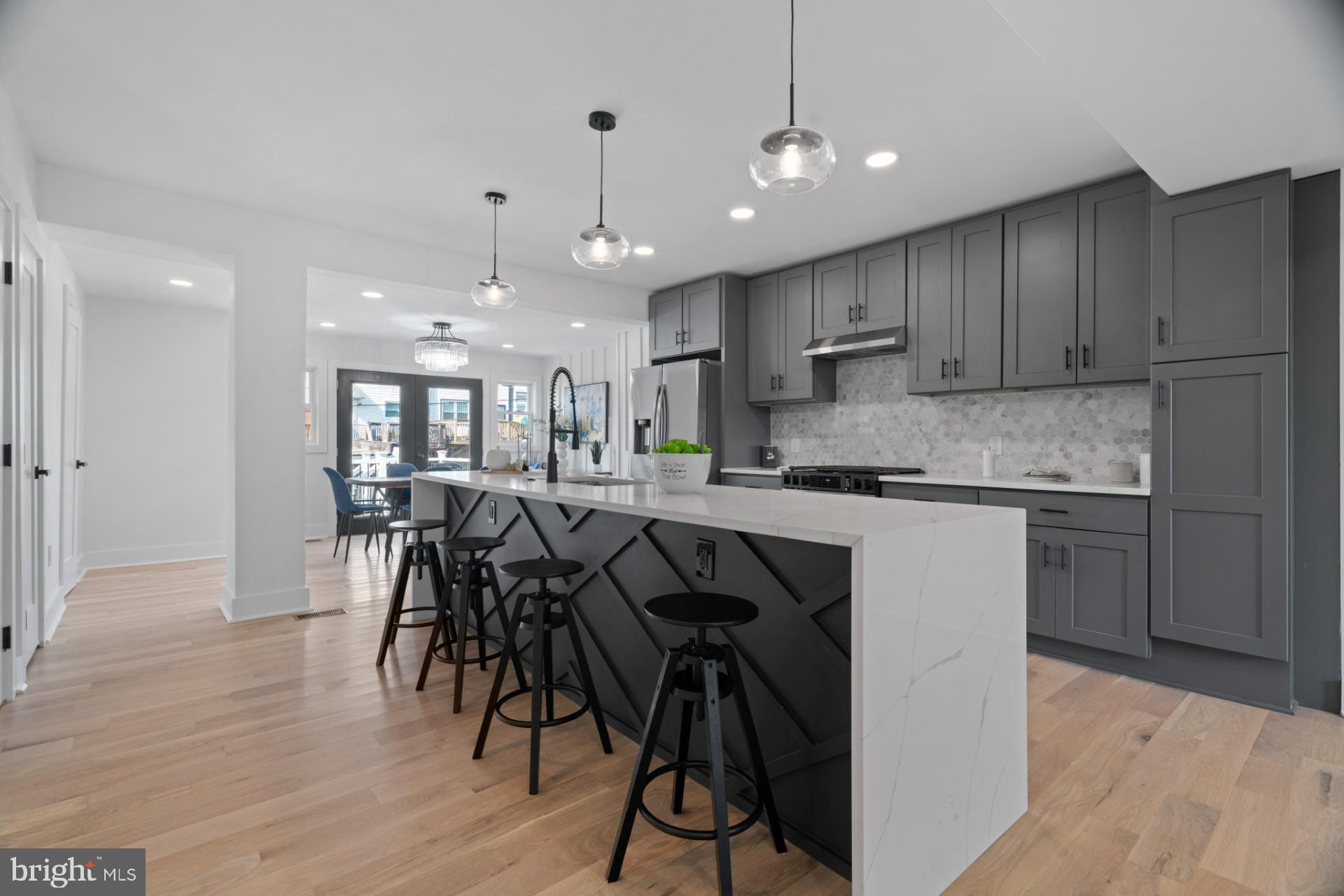 445 Decatur Street Northwest Washington, DC 20011 - Photo 7 of 28 a kitchen with stainless steel appliances granite countertop a table chairs sink refrigerator and microwave