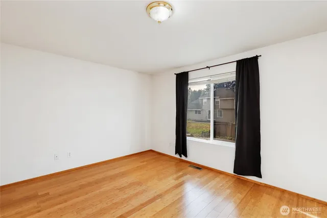 a view of a big room with wooden floor and windows