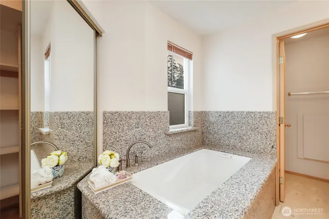 a bathroom with a granite countertop sink a mirror and shower