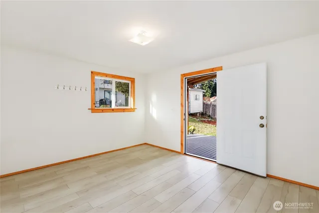 an empty room with wooden floor and window