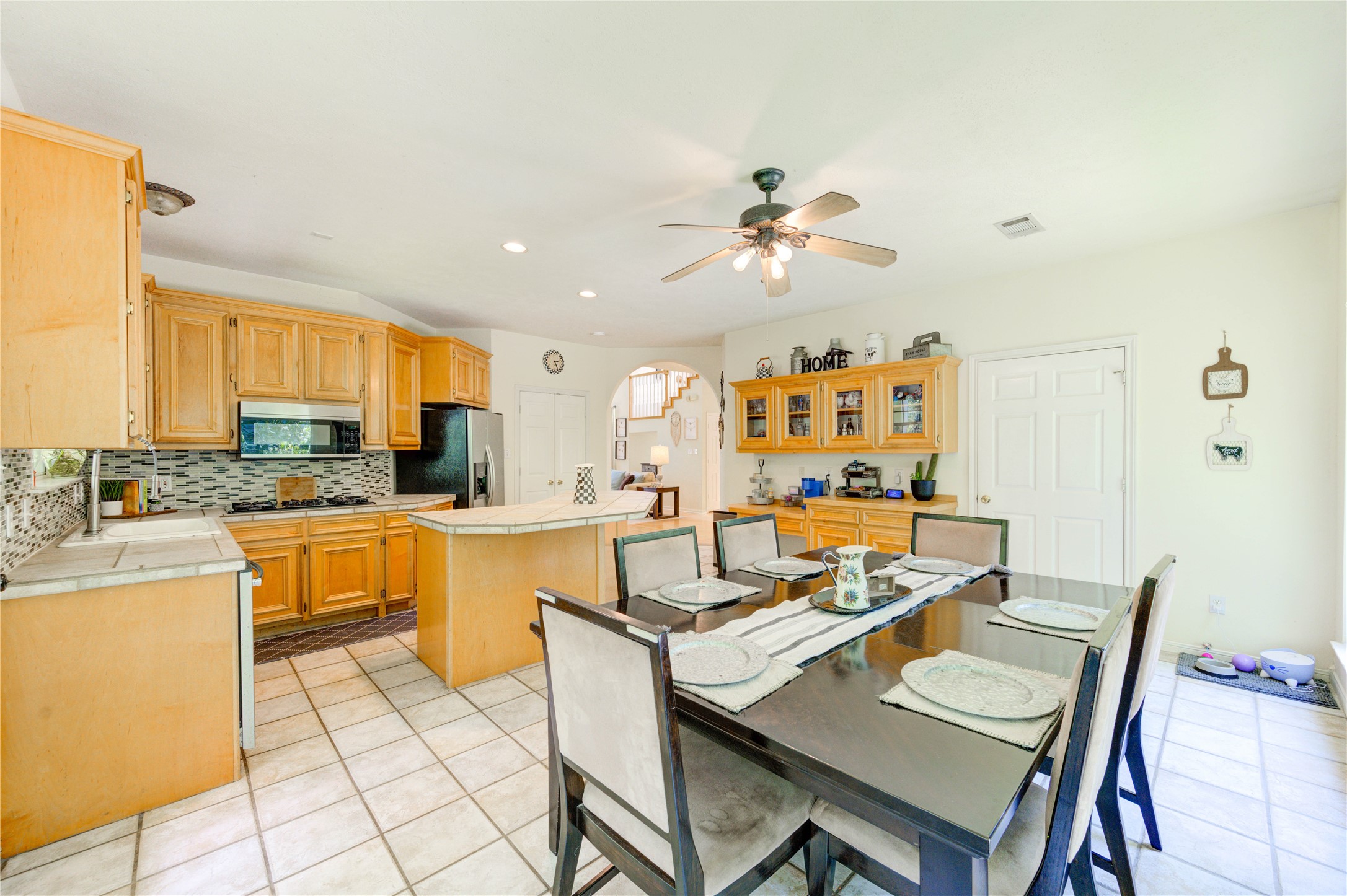 25903 Penguin Street Magnolia, TX 77355 - Photo 35 of 46 a kitchen with a dining table chairs and white appliances