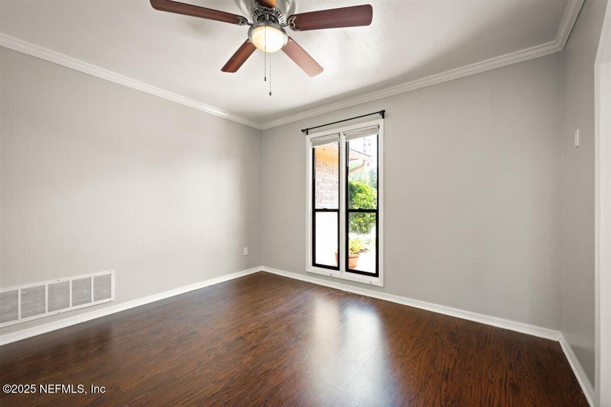 2477 Ridgecrest Avenue Orange Park, FL 32065 - Photo 7 of 28 an empty room with wooden floor fan and windows