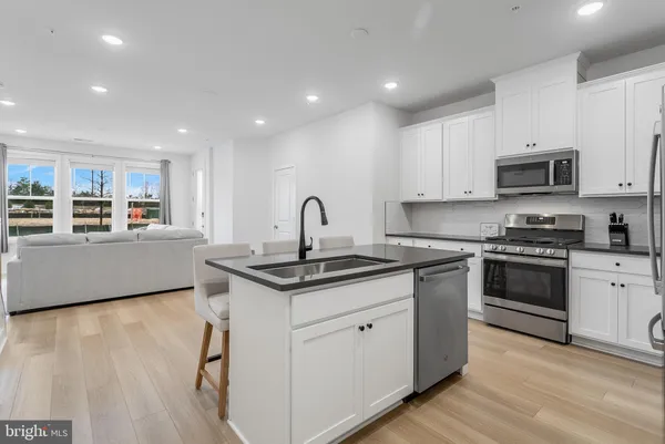 a kitchen with kitchen island a sink stainless steel appliances and cabinets