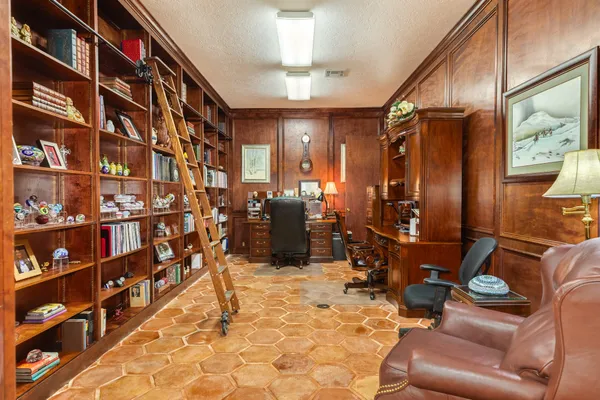 a view of a livingroom with bookshelf and furniture