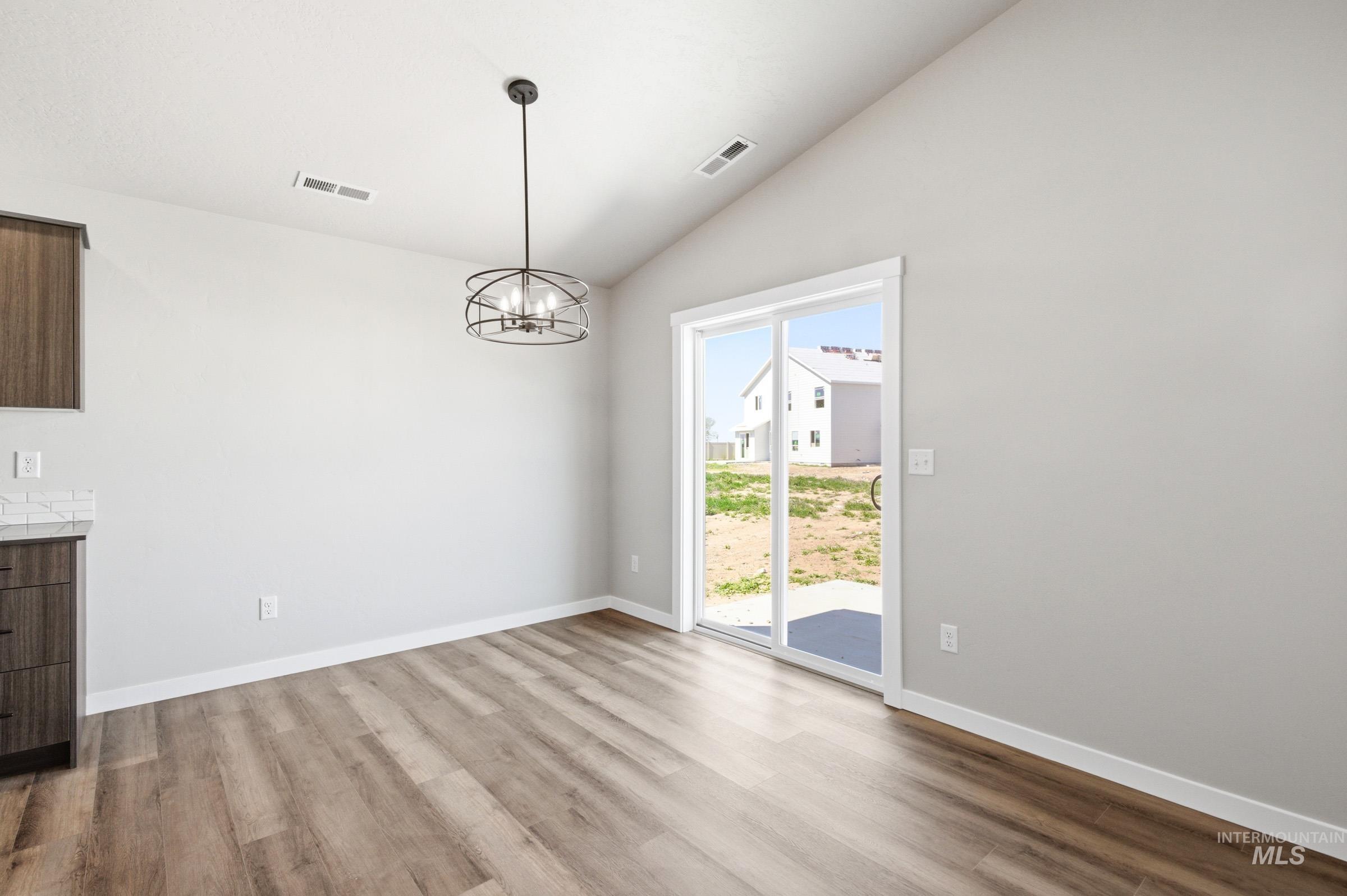 12805 Decatur Street Nampa, ID 83651 - Photo 6 of 20 Spacious interior with vaulted ceilings, wood-finish flooring, and a modern chandelier