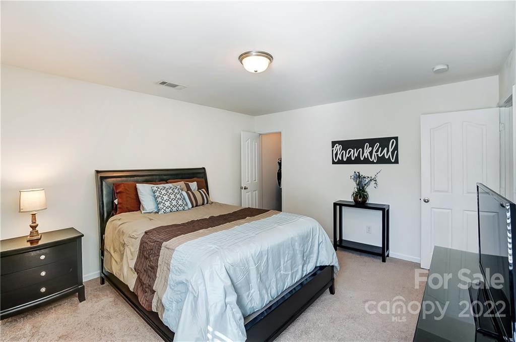 4715 McClure Road Charlotte, NC 28216 - Photo 23 of 36 a bedroom with a bed and a lamp on dresser