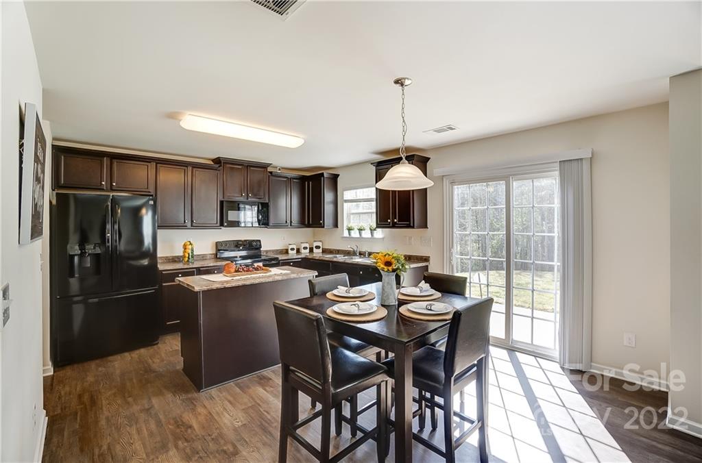 4715 McClure Road Charlotte, NC 28216 - Photo 8 of 36 a kitchen with a table chairs refrigerator and microwave