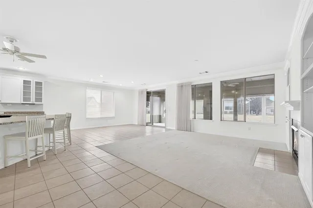 a big room with chandelier fan and windows