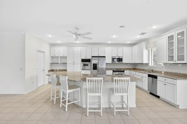 a kitchen with a dining table chairs and cabinets