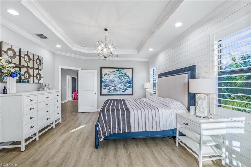 4605 Abaca Circle Naples, FL 34119 - Photo 12 of 35 a bedroom with a large bed and a dresser