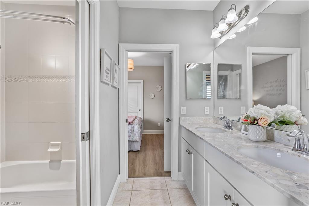 4605 Abaca Circle Naples, FL 34119 - Photo 19 of 35 a spacious bathroom with a granite countertop sink a toilet and a mirror