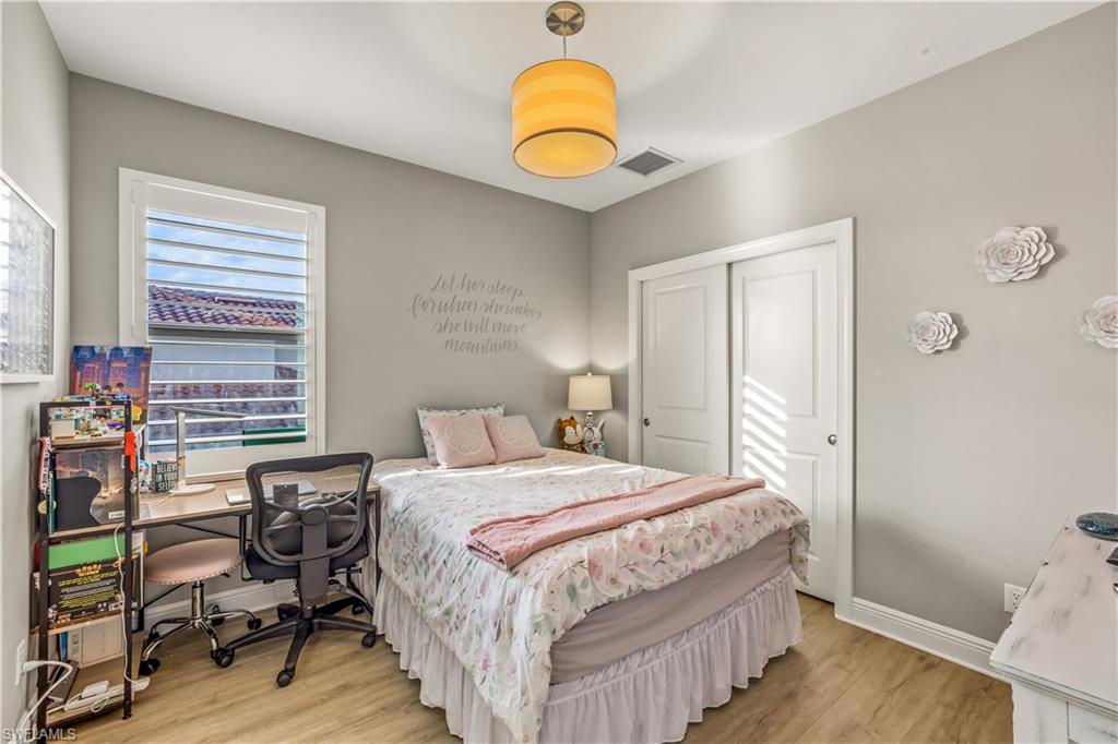 4605 Abaca Circle Naples, FL 34119 - Photo 20 of 35 a bedroom with a bed and wooden floor