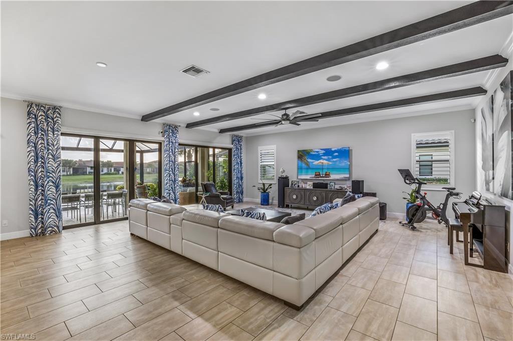 4605 Abaca Circle Naples, FL 34119 - Photo 2 of 35 a living room with furniture and a flat screen tv