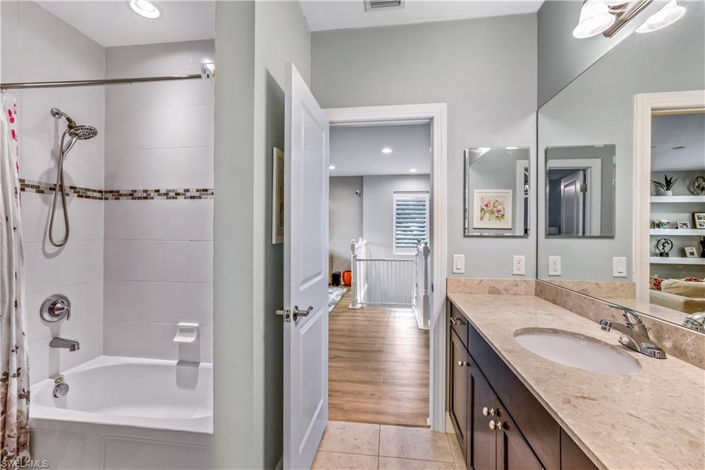 4605 Abaca Circle Naples, FL 34119 - Photo 22 of 35 a bathroom with a granite countertop sink mirror and a bath tub