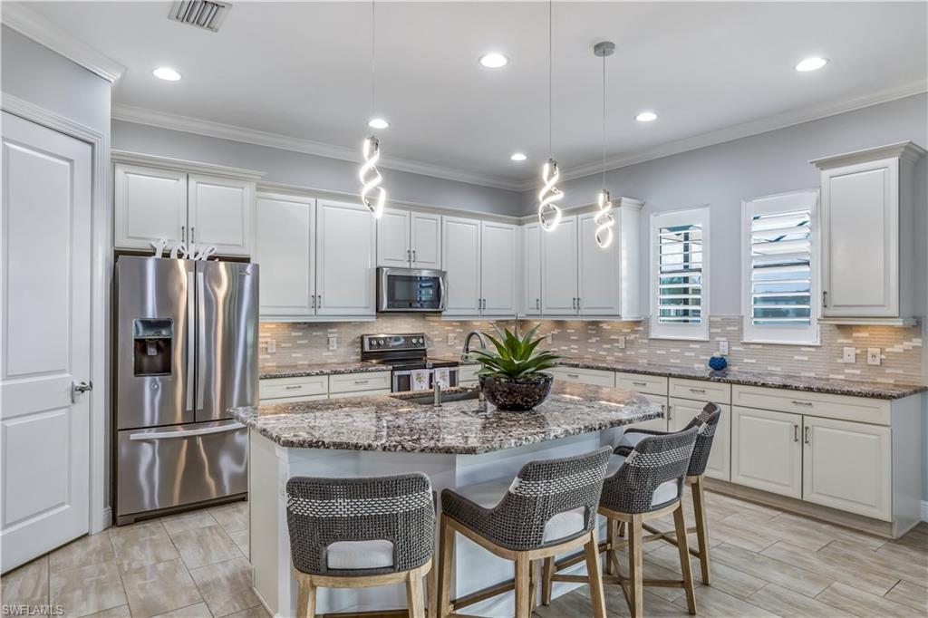 4605 Abaca Circle Naples, FL 34119 - Photo 3 of 35 a kitchen with granite countertop a center island stainless steel appliances and cabinets