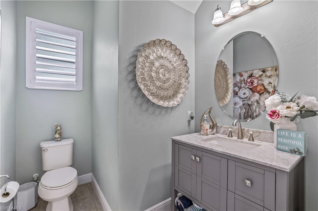 4605 Abaca Circle Naples, FL 34119 - Photo 9 of 35 a bathroom with double vanity a toilet a and mirror