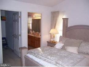 196 Torpedo Road Manahawkin, NJ 08050 - Photo 2 of 6 a bedroom with a bed and a chandelier