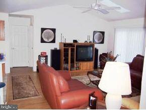196 Torpedo Road Manahawkin, NJ 08050 - Photo 5 of 6 a living room with furniture a flat screen tv and kitchen view