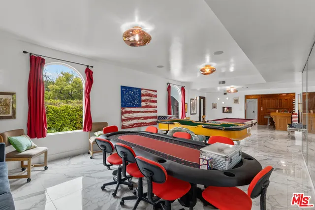 a living room with furniture pool table and flat screen tv