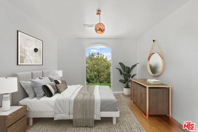 a bed room with a bed mirror and a window