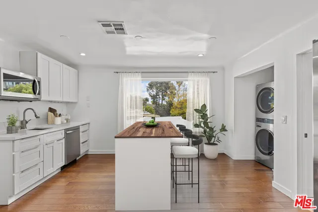 a kitchen with a sink a counter space and stainless steel appliances