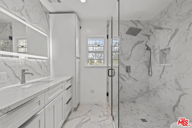 a bathroom with a shower sink and mirror