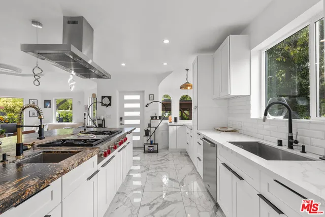 a kitchen with stainless steel appliances granite countertop a sink stove and cabinets