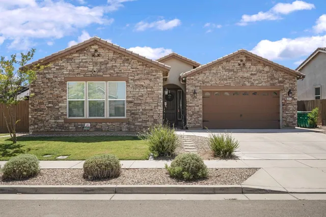 a spacious bedroom with a bed and a chandelier