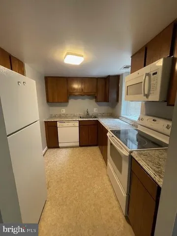 a kitchen with stainless steel appliances granite countertop a refrigerator a stove a sink and a microwave