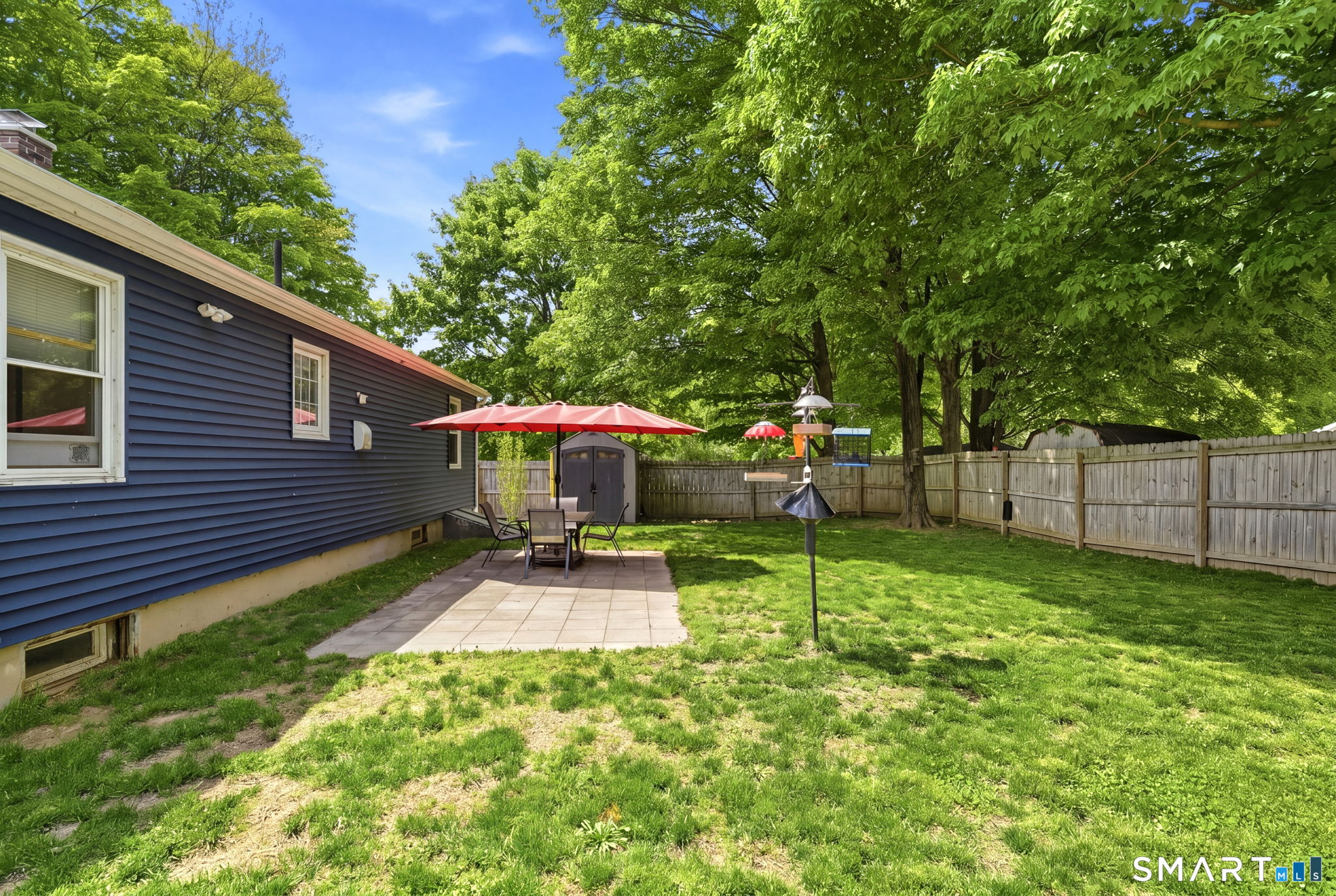 71 Smith Street Putnam, CT 06260 - Photo 19 of 25 a view of a backyard with table and chairs under an umbrella