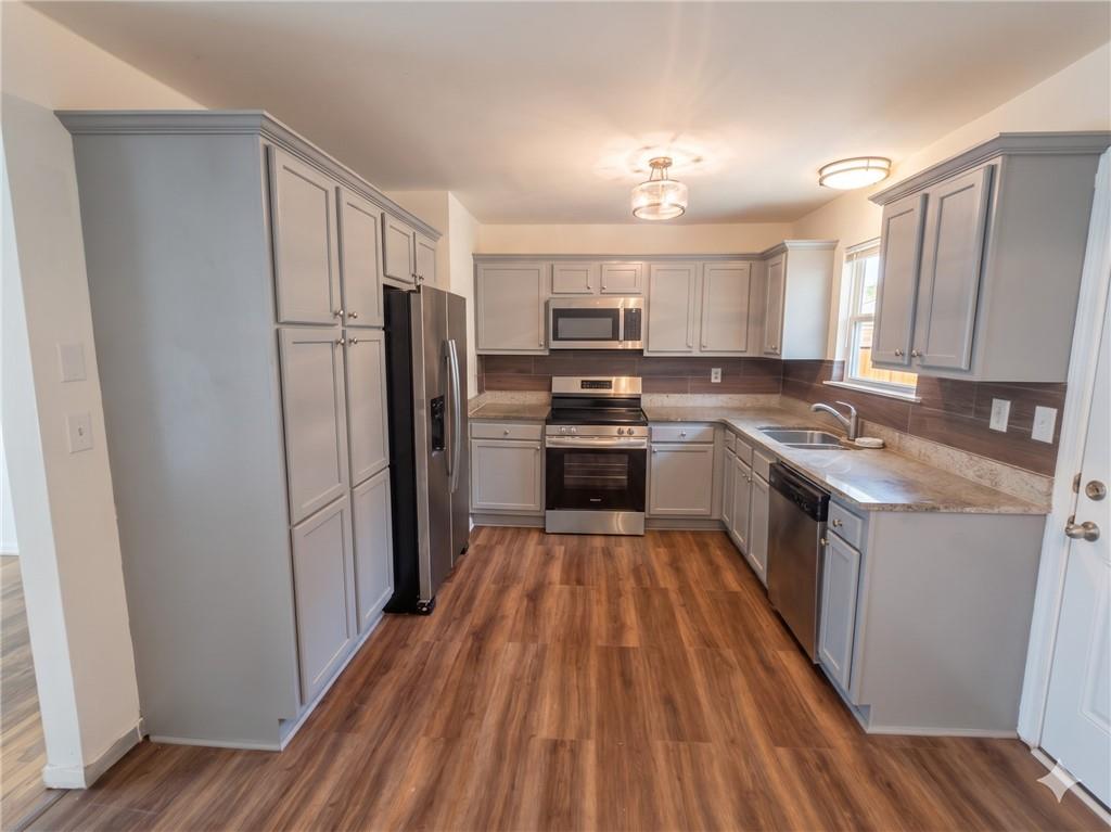 1929 Wee Kirk Road Southeast Atlanta, GA 30316 - Photo 6 of 22 a kitchen with kitchen island wooden floors appliances and cabinets