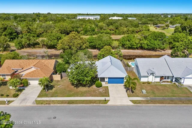 an aerial view of residential houses with outdoor space and swimming pool